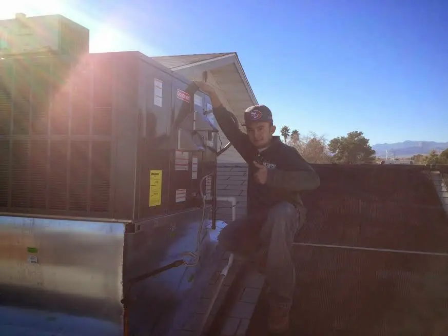 HVAC technician performing Heat Pump Repair on a rooftop unit in Augusta